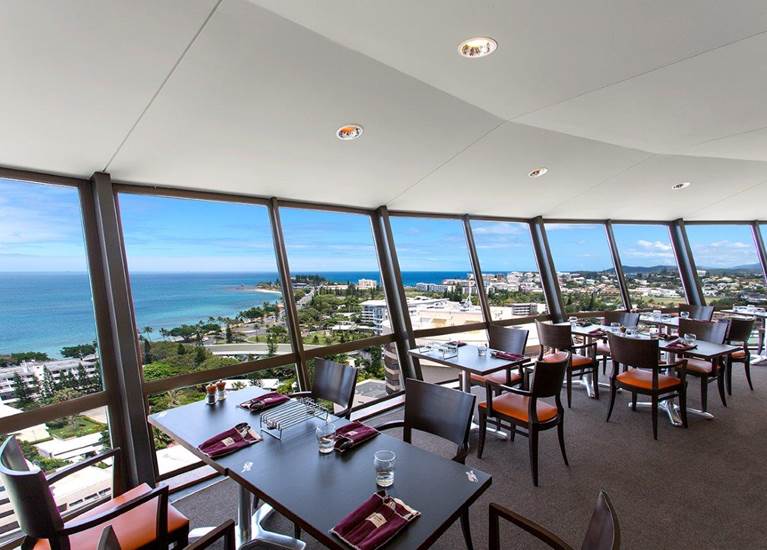 Vue de l'intérieur du restaurant. Une vue panoramique sur la mer et la plage de l'Anse Vata et de la Baie des Citrons est en arrière plan.