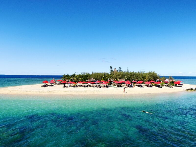 Vue panoramique sur l'îlot Canard et ses parasols rouges.