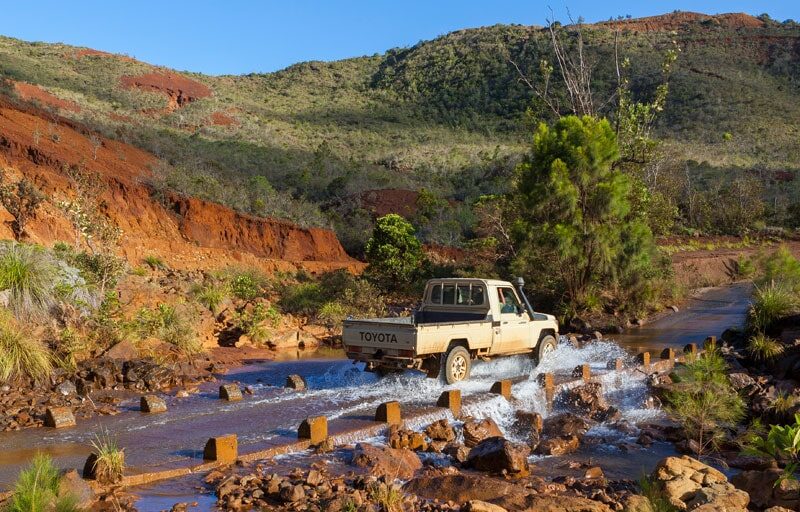 Photo d'un pickup traversant un passage recouvert d'eau à Yaté dans le Sud de la Nouvelle-Calédonie.