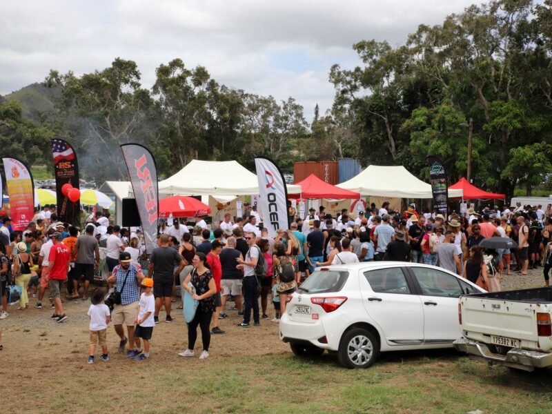 Photo d'une allée de la fête du bœuf en Nouvelle-Calédonie. On y voit plusieurs stands alignés avec de nombreuses personnes devant.