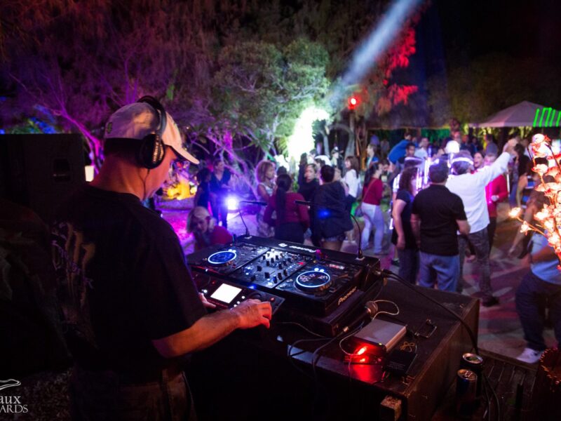 Photo d'un événement sur l'île aux canards. La photo est prise depuis la zone de mixage du DJ. On y voit de nombreuses personnes danser.