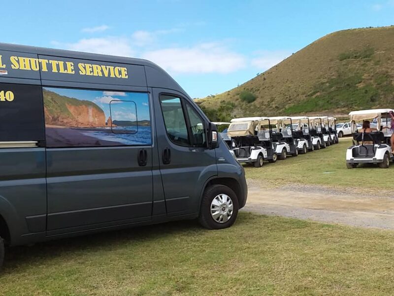 Photo d'un des véhicules de Bourail Shuttle Service, un minibus. Des voiturette du Sheraton sont visible en arrière plan.