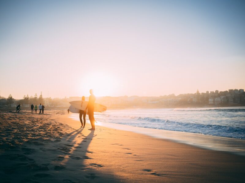 Surfeurs au coucher du soleil sur la plage de Bondi Beach en Australie